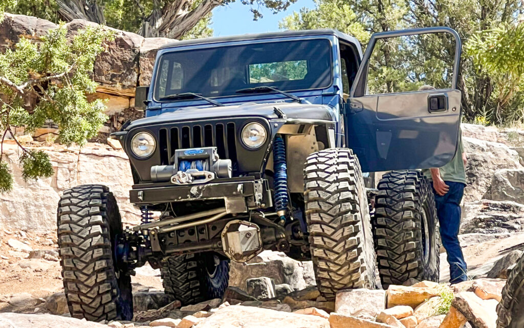Jeep steering components after a lift showing tie rod and drag link